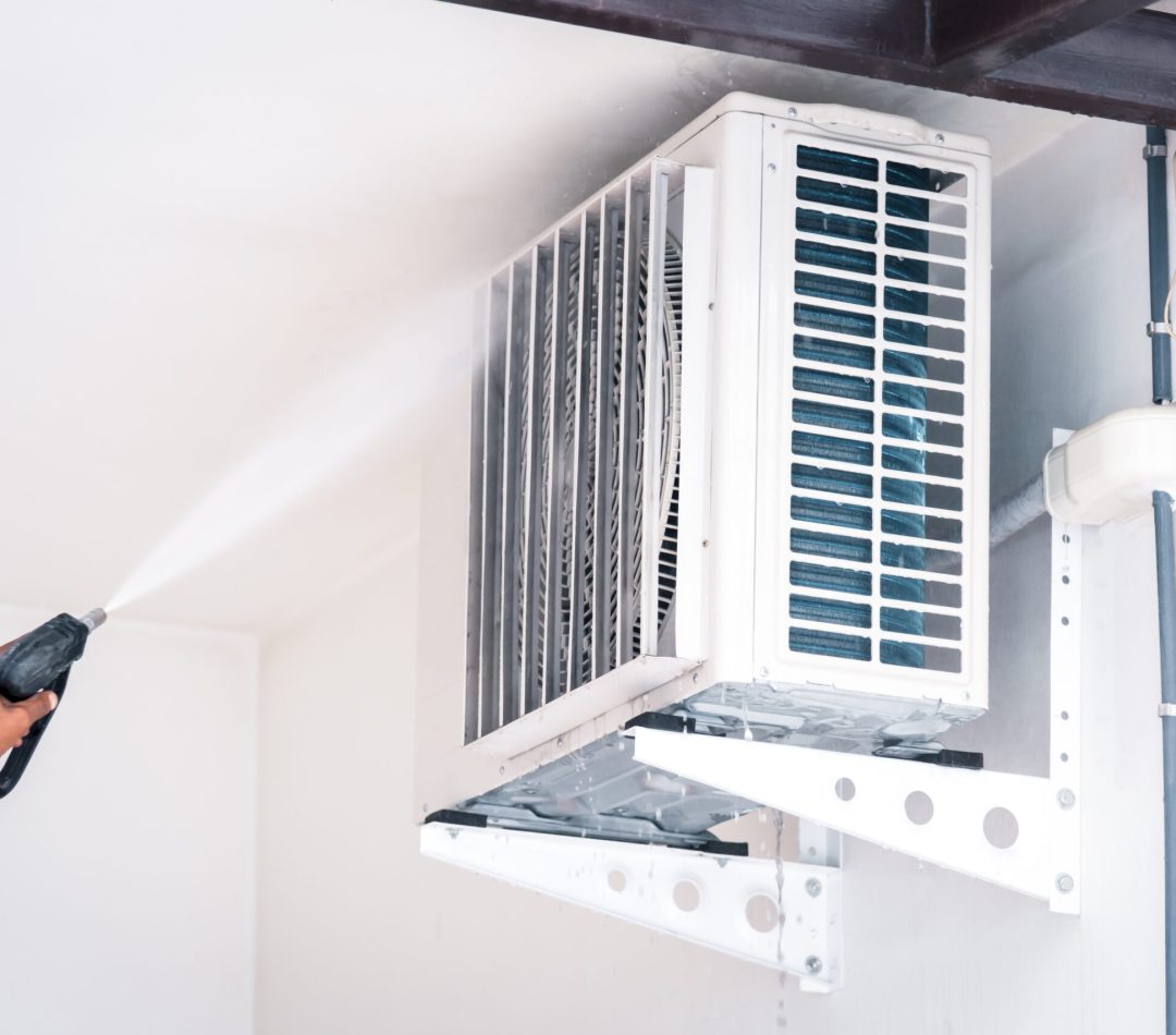 Cleaning air conditioner by water for clean a dust Worker to cleaning coil cooler of air conditioner by water for clean a dust on the wall in customer home when maintenance service